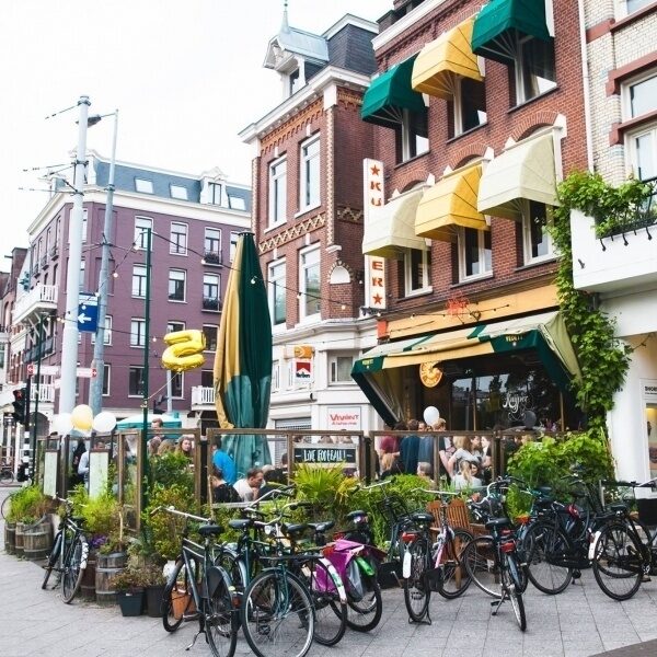 Het karakteristieke hoekpand van Café Kuijper met terras en groene luifels
